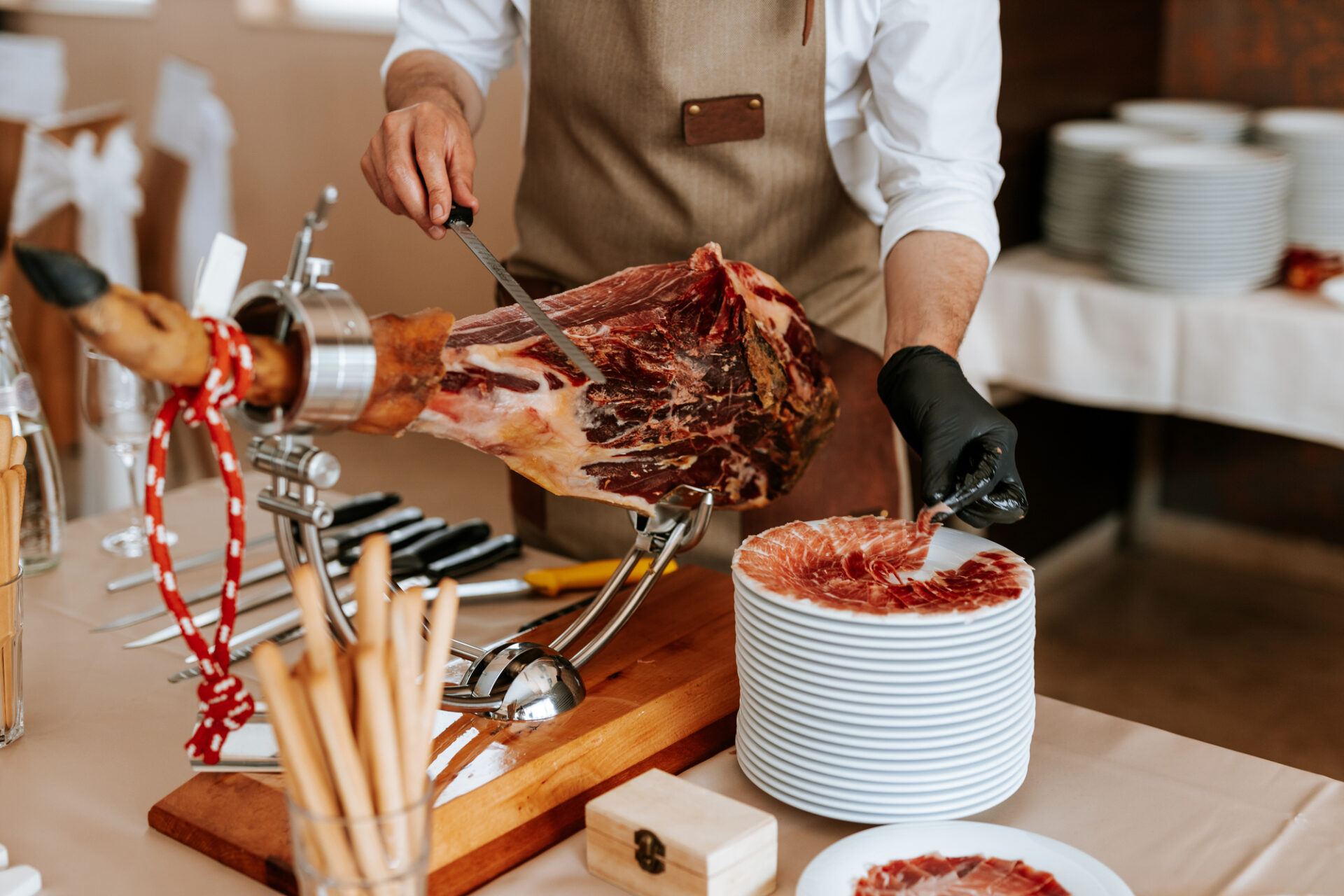 Closeup of chef hands when cut and serve a slice of traditionally spanish jamon